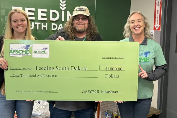 Photo of Development Officer Jennie Palmer, Local 1031 president Sean Jewett and Council 65 Labor Representative Darby Boyd with a check